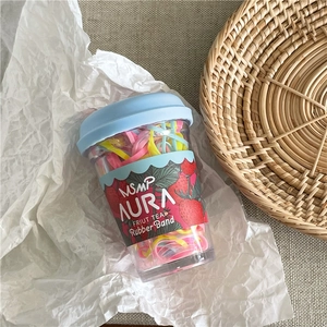 Top view of colorful elastic hair bands inside a creative strawberry-themed cup container