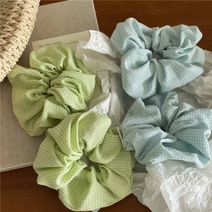 Détail de quatre chouchous en tissu à carreaux vichy dans les tons bleu et vert clair