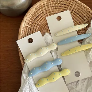 Cute cream-colored wavy polka dot hair clips for girls displayed on white card