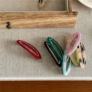 Macro detail of tortoiseshell acetate hair clips with crystal edges and France engraving