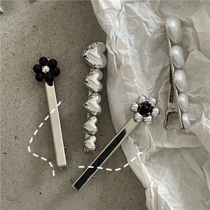 Détail d'un lot de quatre barrettes à fleurs et cœurs en argent et perles