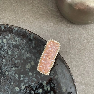 Close-up of pink crystal hair clip with sparkling rhinestones on vintage plate