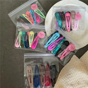 Close-up of colorful teardrop BB hair clips in cream tones and transparent packaging