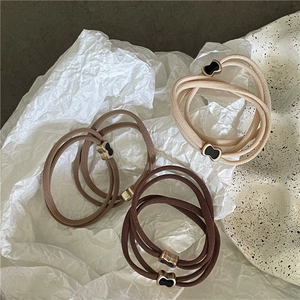 Dettaglio di elastici per capelli con ciondoli in metallo su un piatto in ceramica