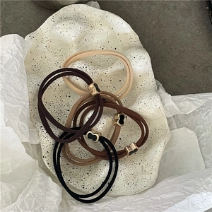 Dettaglio ravvicinato di elastici per capelli con accenti metallici a forma di cuore