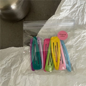Set of eight colorful matte snap hair clips in a clear pouch with a thank you sticker