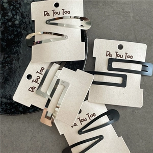 Matte black and silver metallic hair clip set with rectangle and teardrop shapes on a card