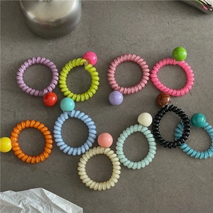 Vue à plat d'élastiques à cheveux spirale colorés avec perles rondes acidulées
