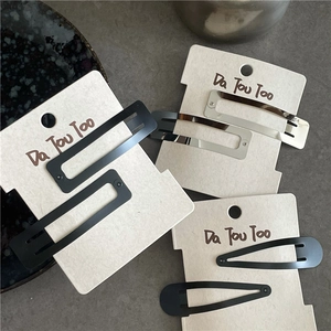 Matte black and silver metallic hair clips in rectangle and waterdrop shapes on card