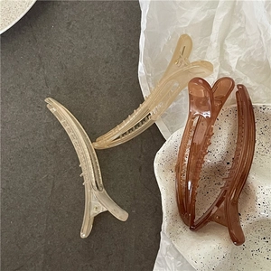 Detail shot of four translucent jelly-textured hair clips in amber and champagne tones