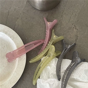 Translucent jelly hair clips in five colors on a marble stone and white tray background