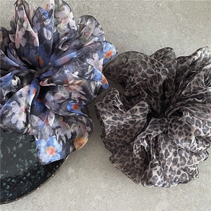 Detailed texture of blue floral and leopard print organza oversized hair scrunchies