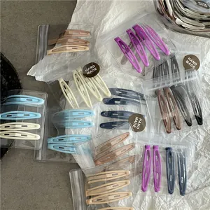 Détail d'un lot de barrettes BB mates multicolores sur fond texturé blanc