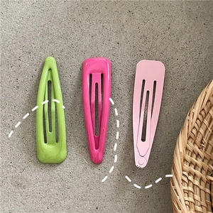 Vue détaillée de trois barrettes goutte colorées aux tons rose, vert et magenta vif