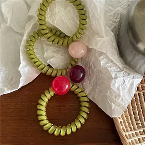 Trois élastiques à cheveux spirale vert translucide avec perles bonbons colorées