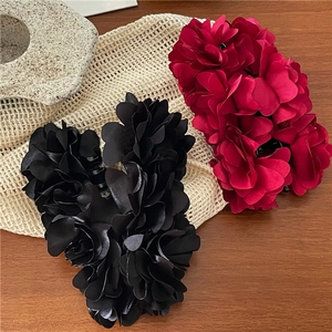 Macro detail of elegant satin rose banana clips in deep burgundy and black colors