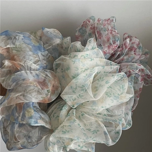 Close-up detail of sheer organza hair scrunchies with elegant floral print patterns