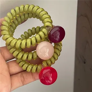 Trois élastiques à cheveux spirales vert olive translucides avec perles de bonbons colorées
