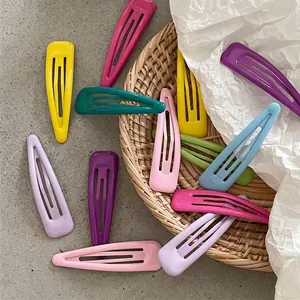 Barrettes à cheveux en métal en forme de goutte aux couleurs pastel sur fond naturel