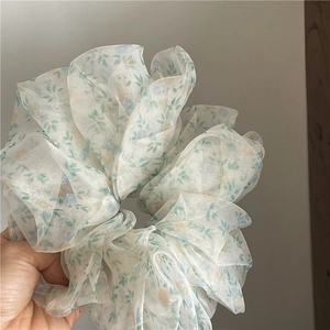Macro detail of breathable oversized floral mesh scrunchie with soft pastel flower print