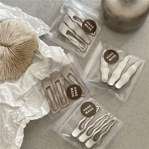 Minimalist matte silver wave hair clip set with rectangle and drop shapes in packaging