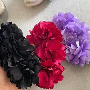 Detailed view of large floral banana clips in wine red, black and purple chiffon fabric