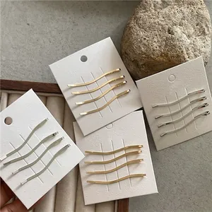 Set di fermagli per capelli a forma di S in metallo dorato e argento su base di cartoncino
