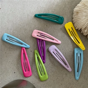 Gros plan de barrettes à cheveux en métal en forme de larme aux couleurs pastel