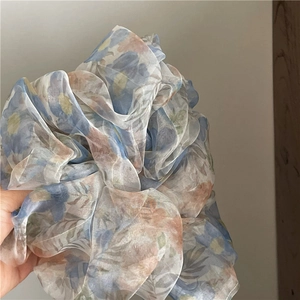 Detail of floral printed mesh scrunchie with soft pastel colors and translucent fabric