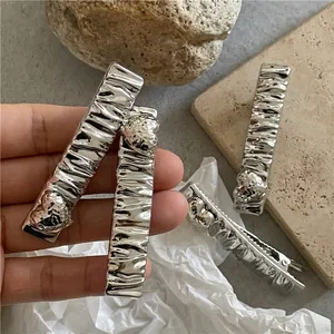 Rectangular silver metal hair clip with natural textured finish and heart detail