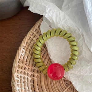 Détail d'un chouchou spirale effet gelée avec une perle décorative rouge brillant
