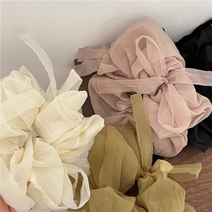 Detail of soft mesh tulle scrunchies with long ribbons in four muted pastel colors