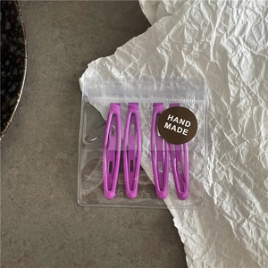 Lot de quatre barrettes ovales violettes dans un sac transparent avec logo fait main
