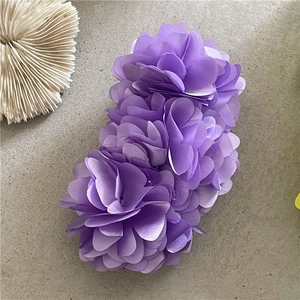 Detailed close-up of large purple chiffon floral banana clip for elegant ponytail hairstyles