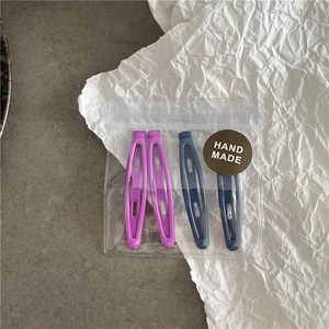 Détail de l'ensemble de barrettes mates violettes et bleu marine en emballage transparent