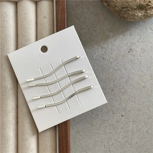 Set di quattro fermagli per capelli argento a forma di S su cartoncino bianco lucido