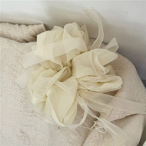 Elegant off-white organza bow scrunchie with soft mesh texture for stylish hair styling