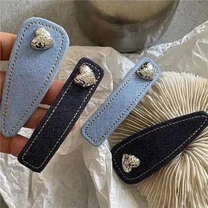 Set of four denim fabric hair clips with silver metal hearts and yellow stitching details