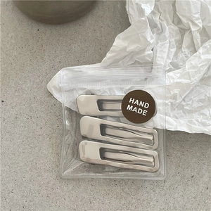 Three-piece matte silver wavy metal hair clips set in transparent packaging