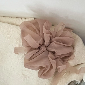 Detail macro shot of large organza scrunchie in soft dusty rose pink mesh fabric