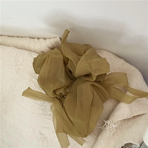 Detailed view of oversized mustard yellow organza scrunchie with layered mesh ruffles