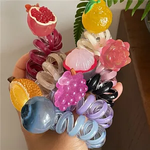 Dettaglio macro di vari elastici a spirale con motivi di frutta e texture gelatina