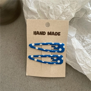 Set mit zwei hellblauen gepunkteten BB-Haarspangen auf handgefertigter Kraftpapierkarte
