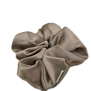 Silky satin coffee brown oversized scrunchie with soft pleated texture and side label
