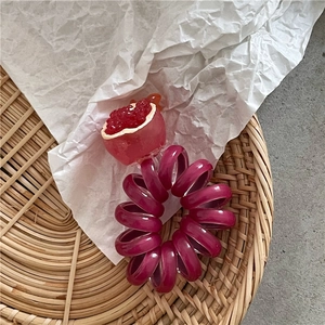 Vista ravvicinata dell'elastico per capelli a spirale con ciondolo a forma di frutta