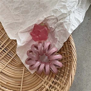 Dettaglio macro dell'elastico a spirale con ciondolo a forma di frutto e texture jelly