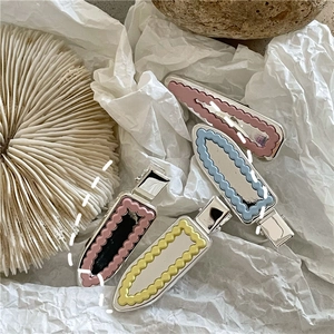 Vue détaillée des barrettes à cheveux à bords ondulés avec finition émail coloré