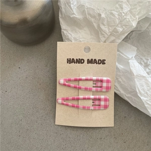 Detailansicht der rosa karierten Tropfen-Haarclips auf handgemachter Verpackung