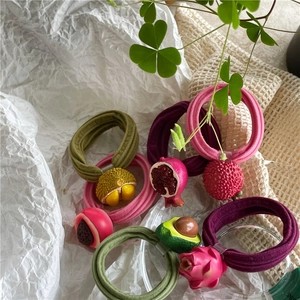 Creative 3D fruit hair ties featuring dragon fruit and durian on a soft white background
