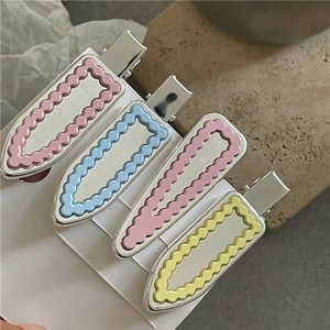 Lot de barrettes géométriques en rose, bleu et jaune sur carte de présentation